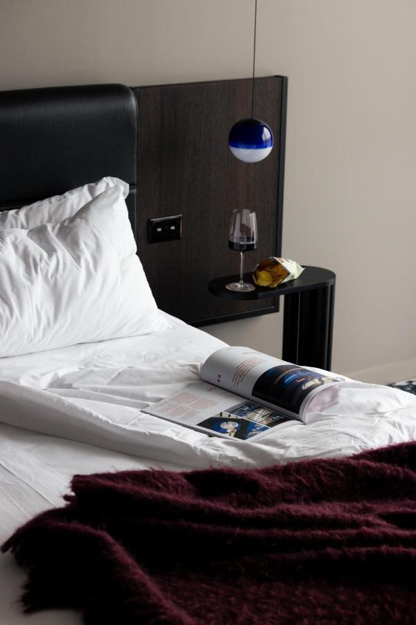 Ebb-Дюндин Екстериор снимка A bed with a magazine and a wine bottle